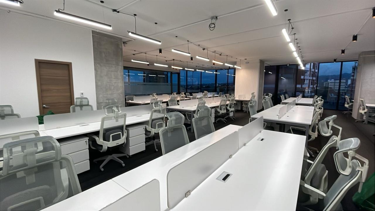 Vista amplia de oficina empresarial con múltiples puestos de trabajo